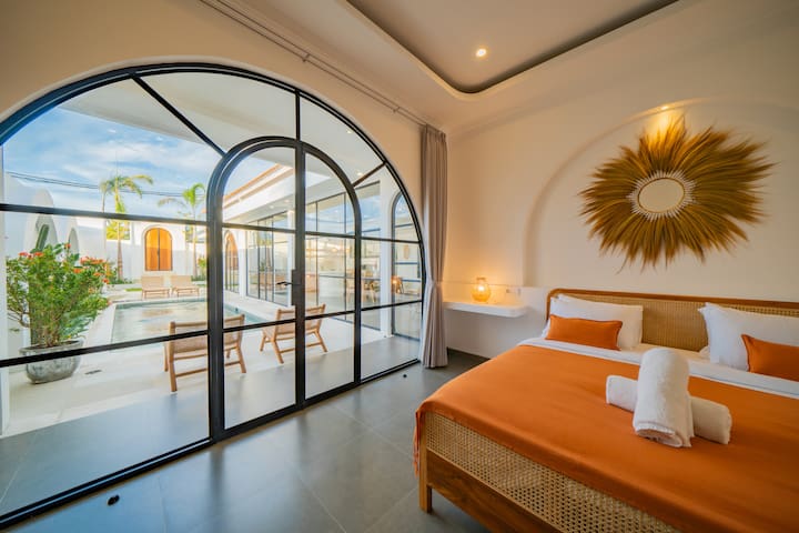 malea-Bedroom Orange Bed Arched Windows